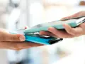 Due mani avvicinano due smartphone per un tap, forse per un pagamento o per scambiare dati.