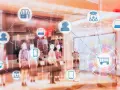Icone di un negozio, carrello, cuffie e dispositivi connessi in una vetrina, che illustrano il retail significato.