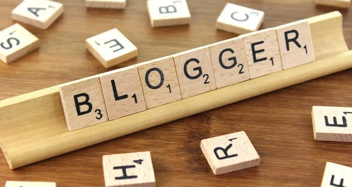 Le tessere del gioco compongono la parola "BLOGGER", definendo il significato di chi condivide pensieri e esperienze online.