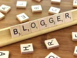 Le tessere del gioco compongono la parola "BLOGGER", definendo il significato di chi condivide pensieri e esperienze online.