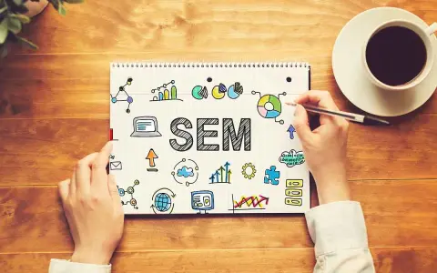 Mani scrivono "SEM" su un quaderno, circondato da icone di grafici, dati e tecnologia. Capire il SEM è fondamentale per il successo online.