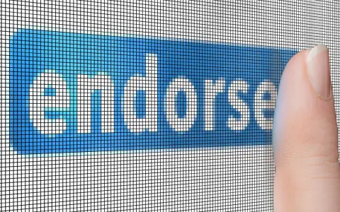 Dito, un dito preme il pulsante "Endorse", che significa approvare o sostenere qualcosa.
