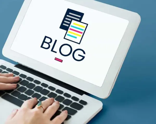 Mani che digitano su un laptop con la parola "BLOG" e un'icona di documenti stilizzati. Scopri il blog personale significato.