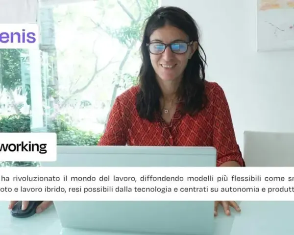 Donna sorridente al computer, simbolo di smart working e del nuovo significato di lavoro da remoto.