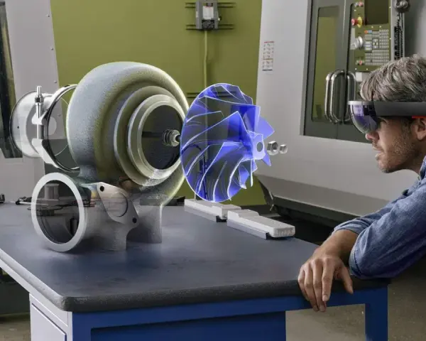 Un uomo con visore AR studia un ologramma di un turbocompressore, esplorando il suo significato tecnologico in officina.