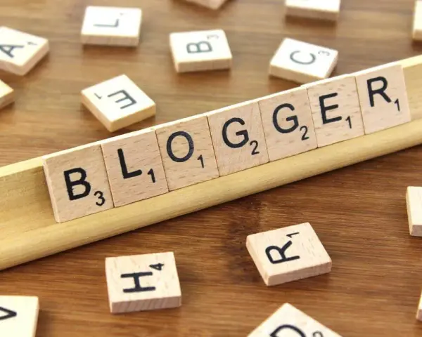 Le tessere del gioco compongono la parola "BLOGGER", definendo il significato di chi condivide pensieri e esperienze online.