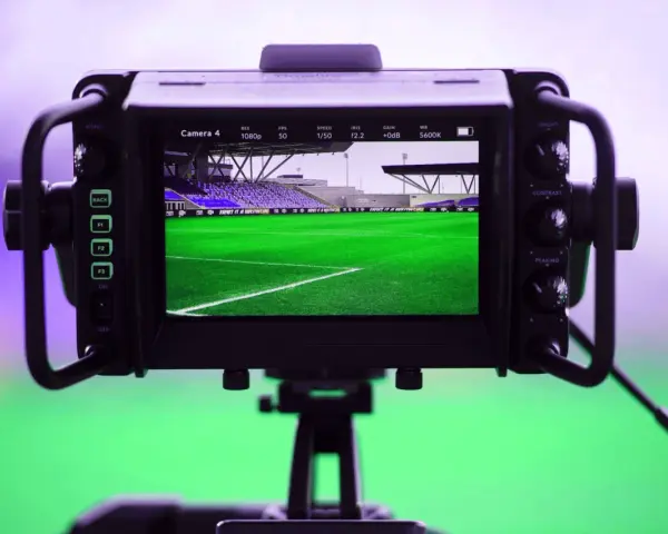 Monitor di ripresa inquadra uno stadio di calcio. La legge anti pezzotto protegge i diritti d'autore, ma la passione per lo sport non si ferma.