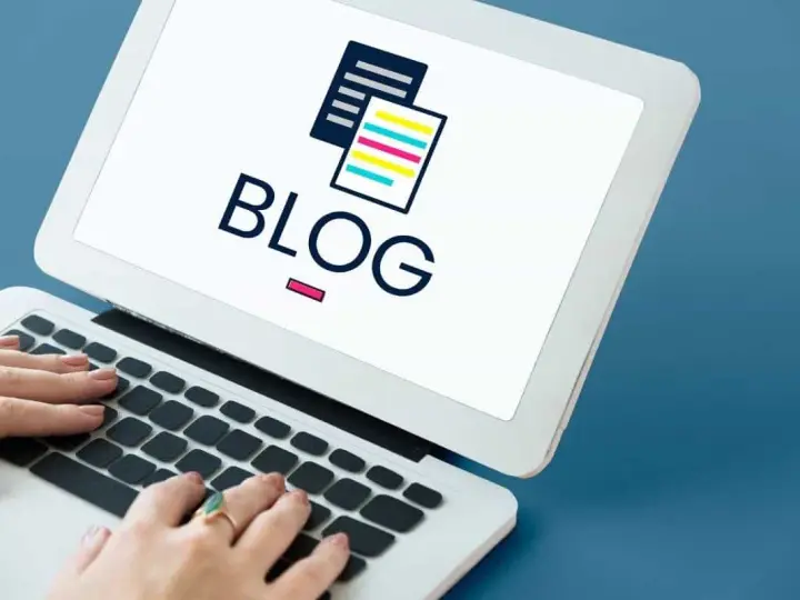 Mani che digitano su un laptop con la parola "BLOG" e un'icona di documenti stilizzati. Scopri il blog personale significato.
