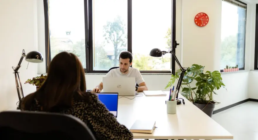 Uomini e donne lavorano in un ufficio moderno, un esempio di coworking. Il significato di coworking è condivisione di spazi e idee.