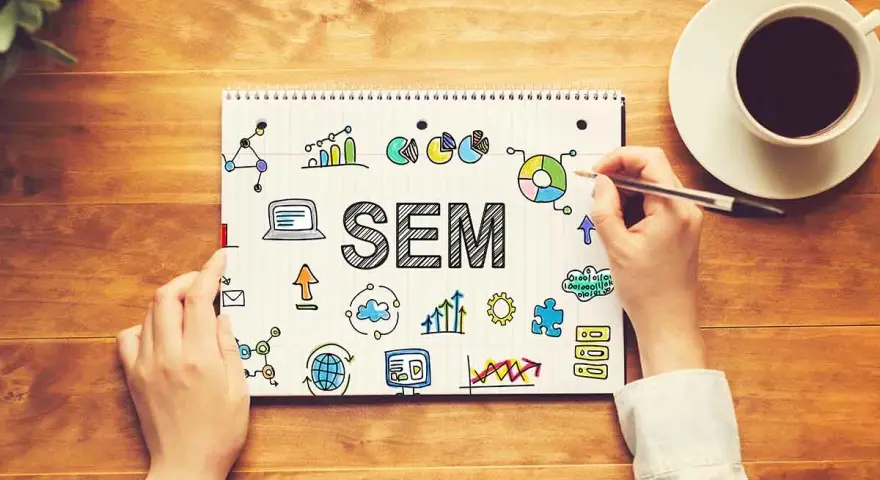 Mani scrivono "SEM" su un quaderno, circondato da icone di grafici, dati e tecnologia. Capire il SEM è fondamentale per il successo online.