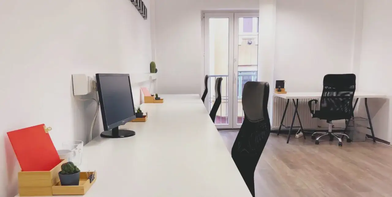 Postazioni di lavoro in un ufficio moderno, che illustra il coworking significato: spazi condivisi per professionisti.