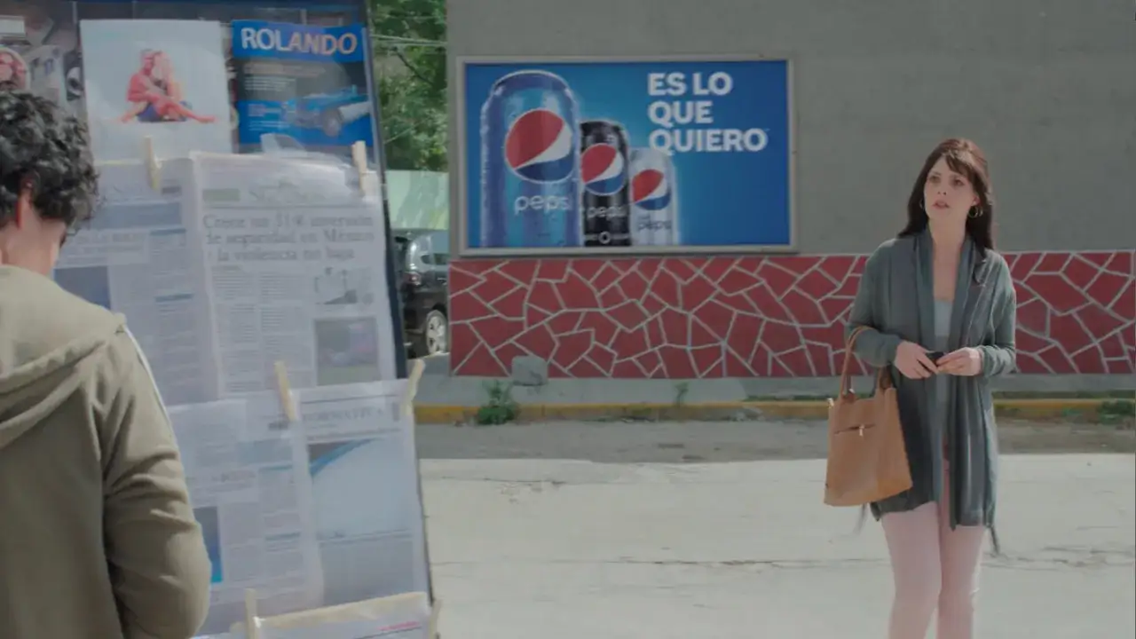 Donna guarda un cartellone Pepsi, un esempio di product placement. La pubblicit&agrave; &egrave; ovunque, anche tra le notizie.