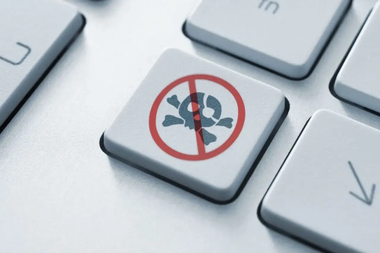 Tasto tastiera con simbolo teschio barrato, simbolo di divieto. La legge anti pezzotto protegge i contenuti digitali.