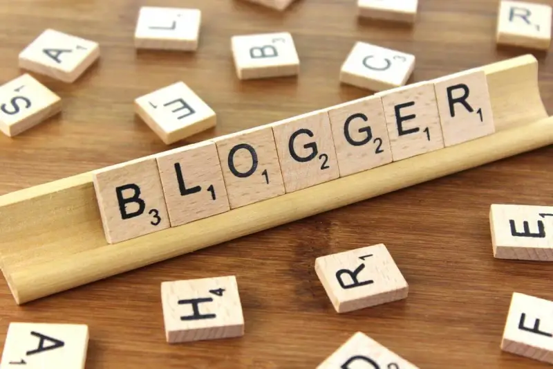 Le tessere del gioco compongono la parola "BLOGGER", definendo il significato di chi condivide pensieri e esperienze online.